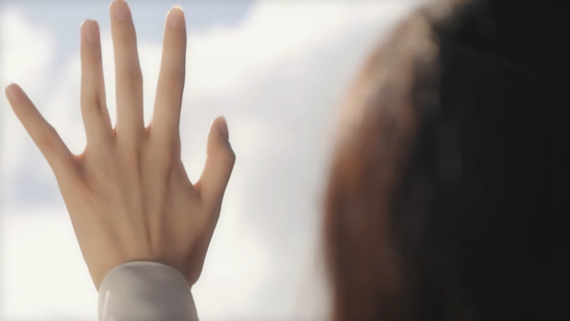 A girl holding her hand up to the sky.